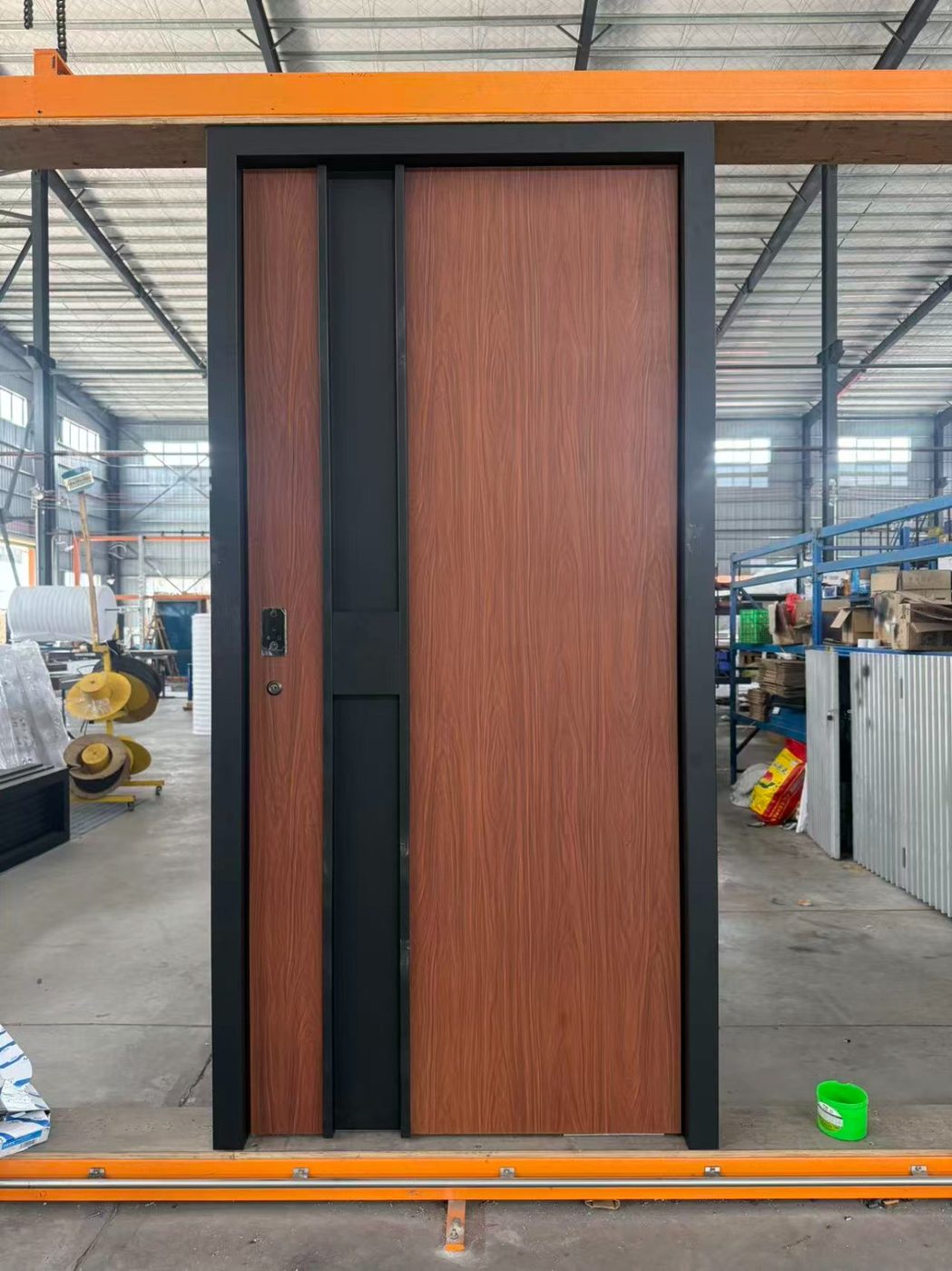 Wood-grain pivot door with a black center inlay and black surround frame